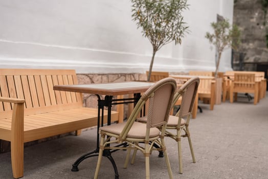 Cafe Table Chairs. Outdoor cafe with wooden furniture, trees, set up daytime for relaxing. photo