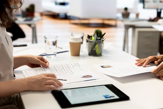 HR employer using tablet during interview to ensure job candidate possesses necessary qualifications fitting for company culture. Recruiter presenting salary package to applicant on device screen photo