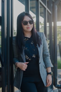 Confident young entrepreneur leaning against modern architecture photo
