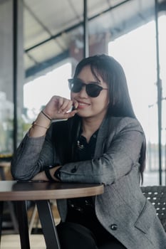 Stylish young woman thinking, wearing a jacket and sunglasses photo