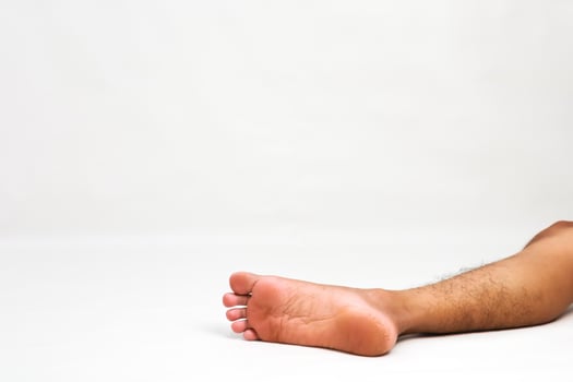Isolated shot of a human foot lying on a plain white background, showcasing foot anatomy photo