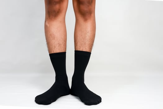 Close-up of legs and feet wearing black socks on a white background illustrating comfort photo