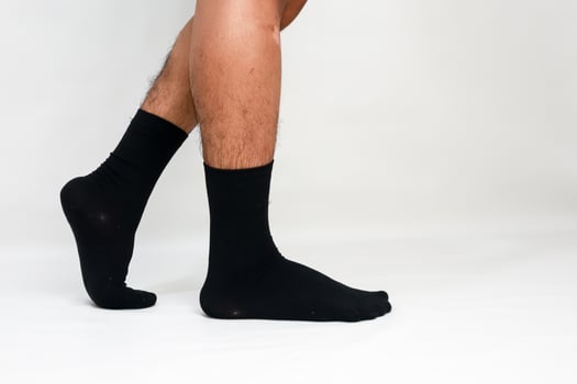 Man wearing black socks on a white background, showcasing comfort and style for footwear enthusiasts and fashion designers photo