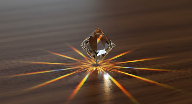 Sparkling crystal reflects light on a wooden surface, creating rainbow color streaks and a sense of purity and brilliance. photo