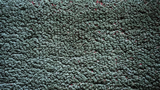 A close up of a carpet with green and red spots photo