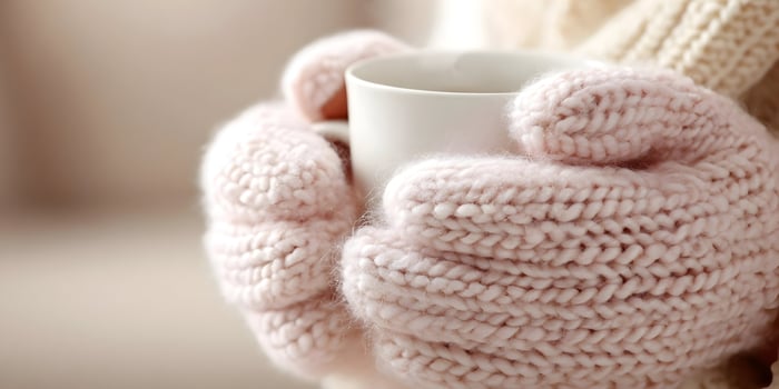 Closeup of Hands in Pink Knitted Gloves Holding a White Mug Cozy Winter Scene photo