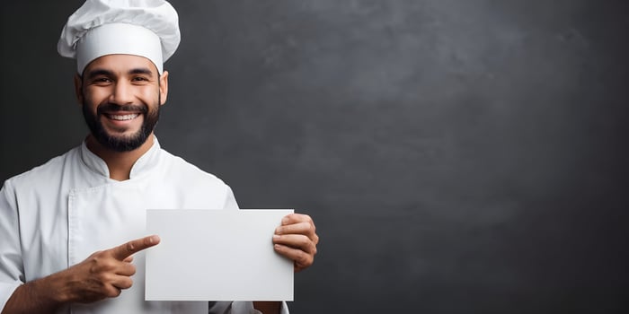 Smiling Male Chef in White Uniform Holding Blank Sign photo