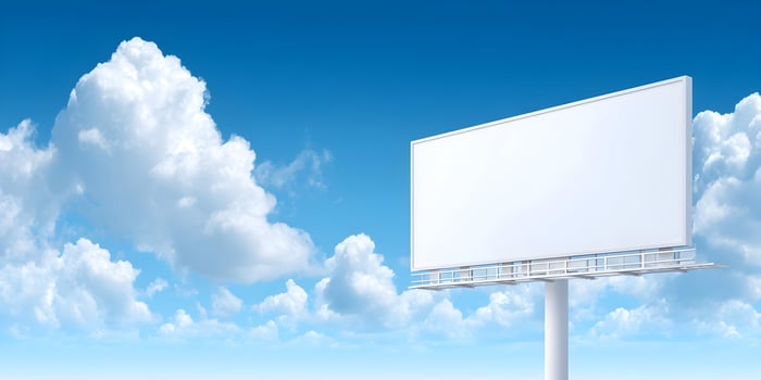an empty billboard on a blue sky with clouds photo