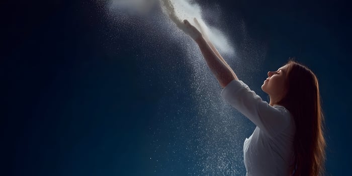 Woman in White Shirt Throwing Powder in Air Dark Background photo