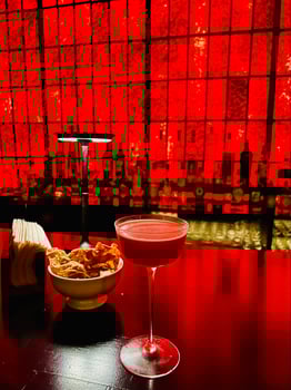 Captured glass of cocktail in a bar with red background photo