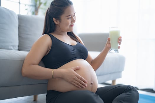 pregnant woman drinking milk and eating a banana photo