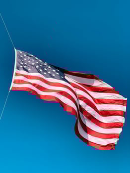 American flag waving in the wind against a clear blue sky background photo