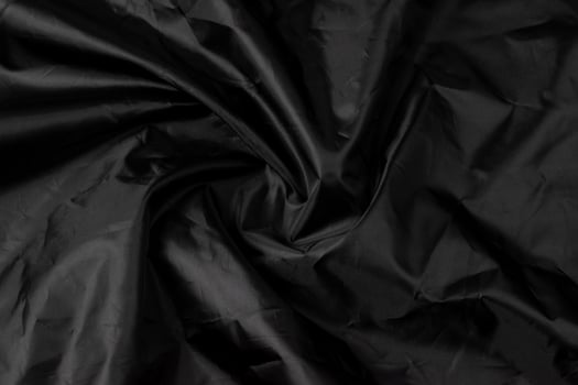 Black background texture. Black colored wavy fabric. photo