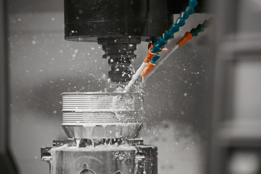 The CNC milling machine cutting the mold parts with oil coolant method. The mold and die manufacturing process by CNC machining center. photo
