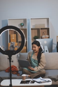 A woman sitting on a couch with a laptop photo