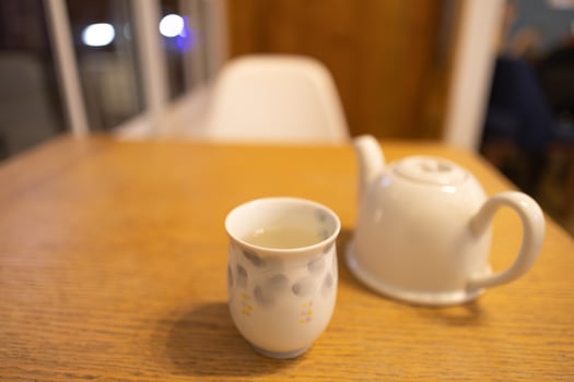 close up cup of Chinese tea and ceramic teapot serve on wooden table photo