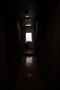 A dark hallway with a light shining through the window photo