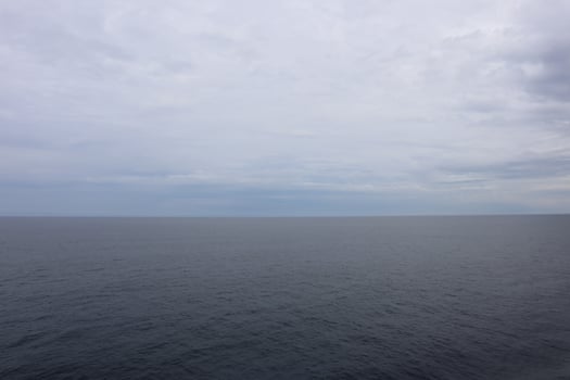 A large body of water with a few clouds photo