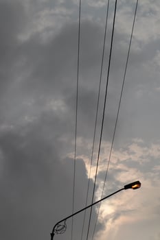 A street light with a cloudy sky behind it photo