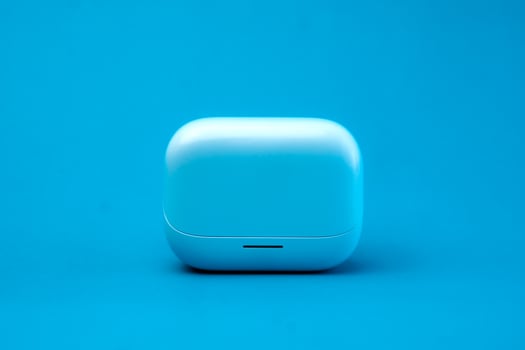 A modern wireless earbuds charging case in a sleek blue design, isolated on a vibrant blue background. Compact, lightweight, and stylish, perfect for travel and daily use. photo