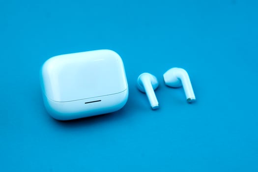 Stylish pair of wireless earbuds with a closed charging case on a blue background. The compact and modern design makes it ideal for music, calls, and on-the-go listening. photo
