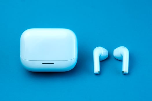 A stylish pair of wireless earbuds with a closed charging case on a blue background. The compact and modern design makes it ideal for music, calls, and on-the-go listening. photo