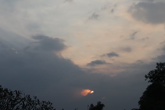 A plane flying through the sky with a sun behind it photo