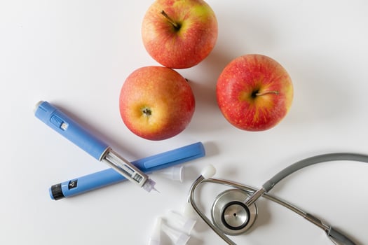 a stethoscope, two apples and a syringe photo