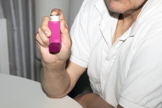 Man holding asthma inhaler in his hands. Asthma medications inhalers on a white background. Lung disease. photo