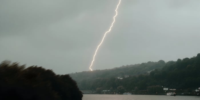 Lightning Strike Over Hilly Landscape near River photo