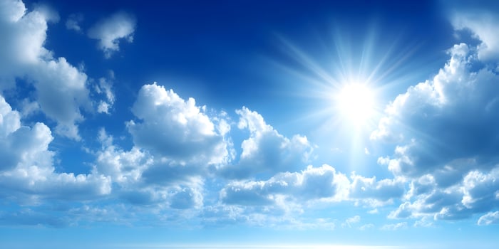 Fluffy clouds floating in a vivid blue sky on a sunny day photo