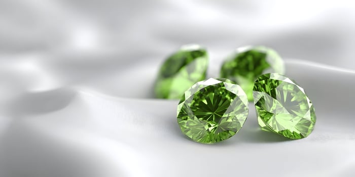 Green Gemstones on White Silk Fabric Luxurious Diamonds Closeup Shot photo