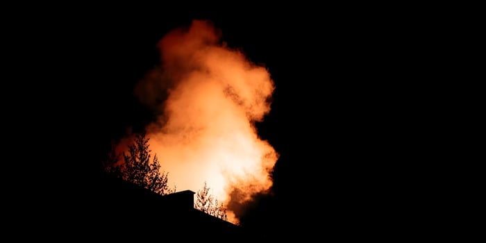 Nighttime Building Silhouette Orange Smoke Plume photo