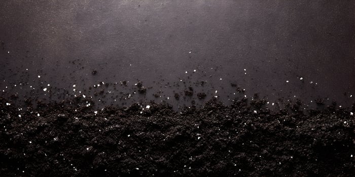 Dark Brown Soil Ground Texture with White Salt Grains Top View photo
