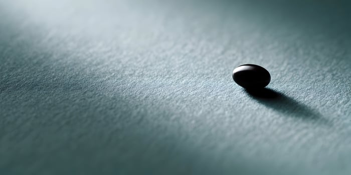 Single Dark Sphere on Teal Textured Surface Minimalist Photography photo
