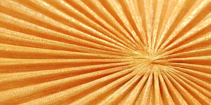Abstract Orange Fabric Texture Sunburst Pattern Pleated Shiny Silk Material Background Design photo