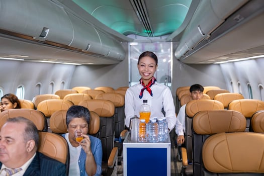 Flight attendant is serving fruit juice to the customer for in flight meal catering, airline travel and transportation concept photo