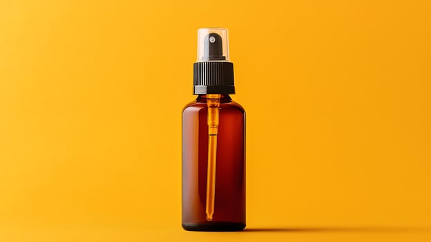 Amber Dropper Bottle with Spray Cap on Yellow Background. This studio shot features a glass dropper bottle with a fine mist spray nozzle, perfect for beauty or cosmetic products. photo