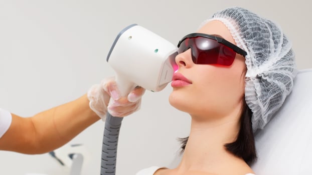 Woman undergoing cosmetic procedures using laser. Advertising concept for facial care, improving skin condition. photo