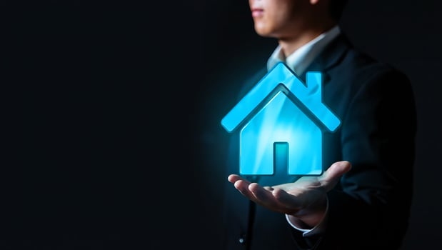 Man holding glowing blue house symbol presenting photo
