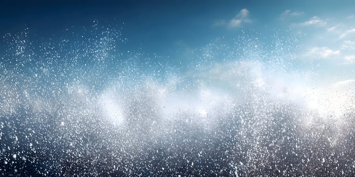 White Particles Exploding Against Blue Sky Background photo