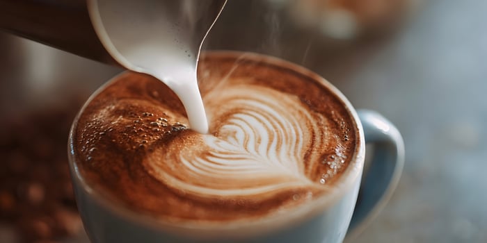 Professional Barista Creating Coffee Art in a Ceramic Cup photo