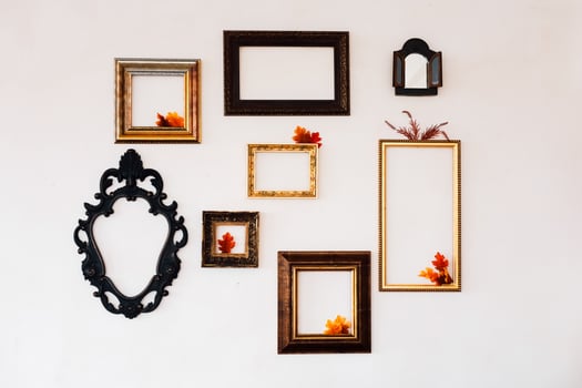 Wall display of empty frames with autumn leaves in a cozy interior setting photo
