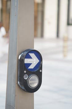 Button for pedestrian crossing in urban setting photo