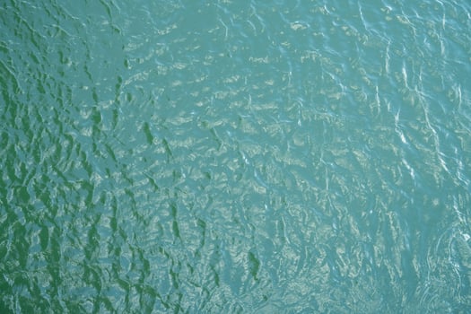 Top view of water surface texture with soft natural ripples. Background for eco-friendly design, peaceful concepts, and water sustainability. Aerial view blue green lake surface water background. photo
