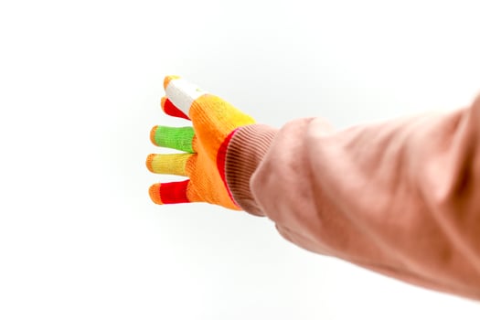 Hand wearing colorful touch screen gloves on a white background in studio shot photo