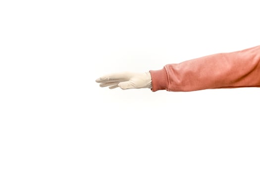 Isolated studio shot of a hand in a latex glove and pink sweater on white background photo