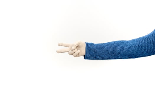 Arm wearing a blue sweater and surgical glove making a peace sign on white background photo