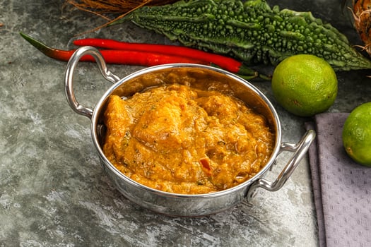 A silver bowl filled with curry and vegetables photo