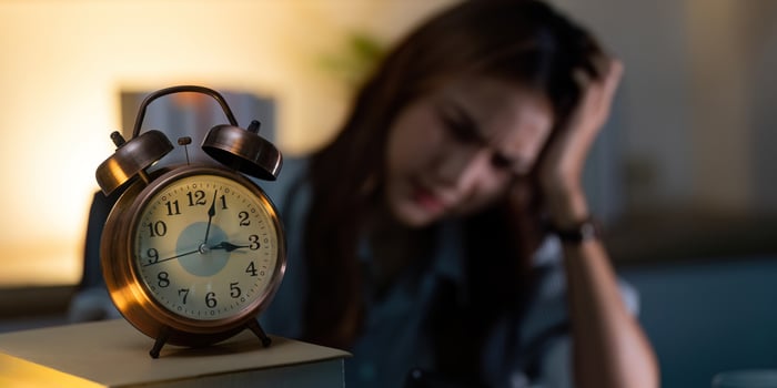 Late Night Alarm. A woman feeling overwhelmed by time pressure while working late. photo